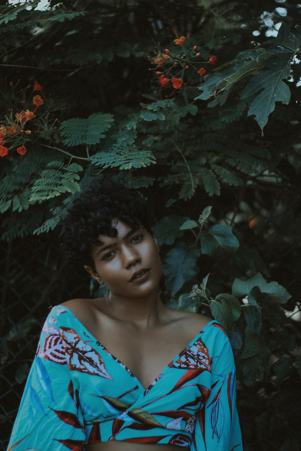 woman wearing blue and red crop-top making post near plant