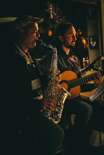 An intimate duo performing softly in a luxurious hotel lounge bathed in warm golden light.