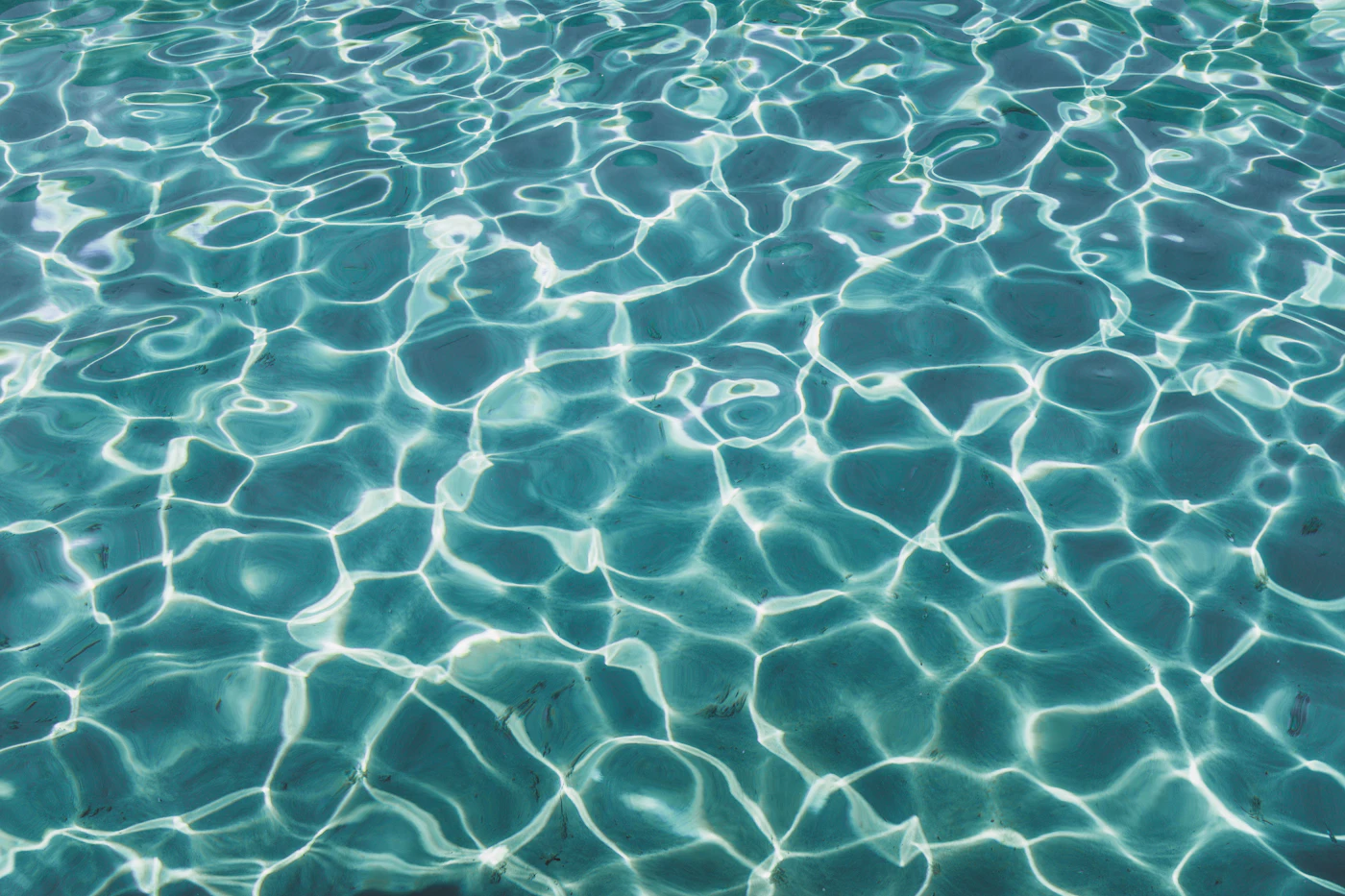 Sunlight on clear blue swimming pool water