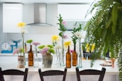 A sparkling clean residential kitchen with shining countertops and fresh flowers on the table.