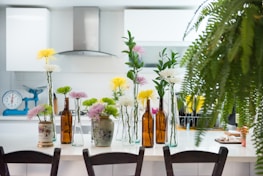 A sparkling clean residential kitchen with shining countertops and fresh flowers on the table.