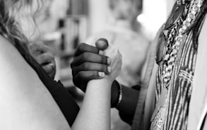 grayscale photo of man and woman holding their hands