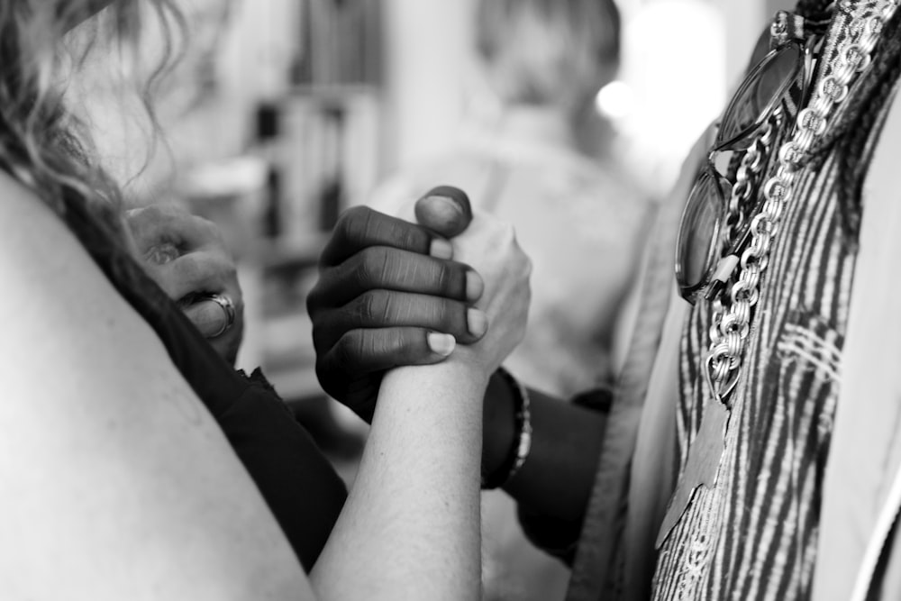 Foto en escala de grises de hombre y mujer tomados de la mano