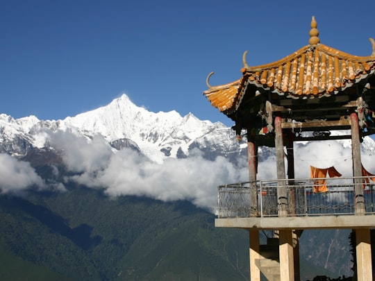 brown wooden watchtower overlooking permafrost mountains in Shangri-La China