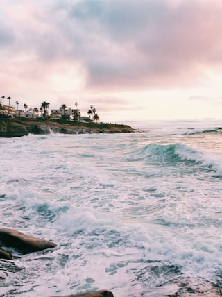 sea waves crashing on shore during golden hour