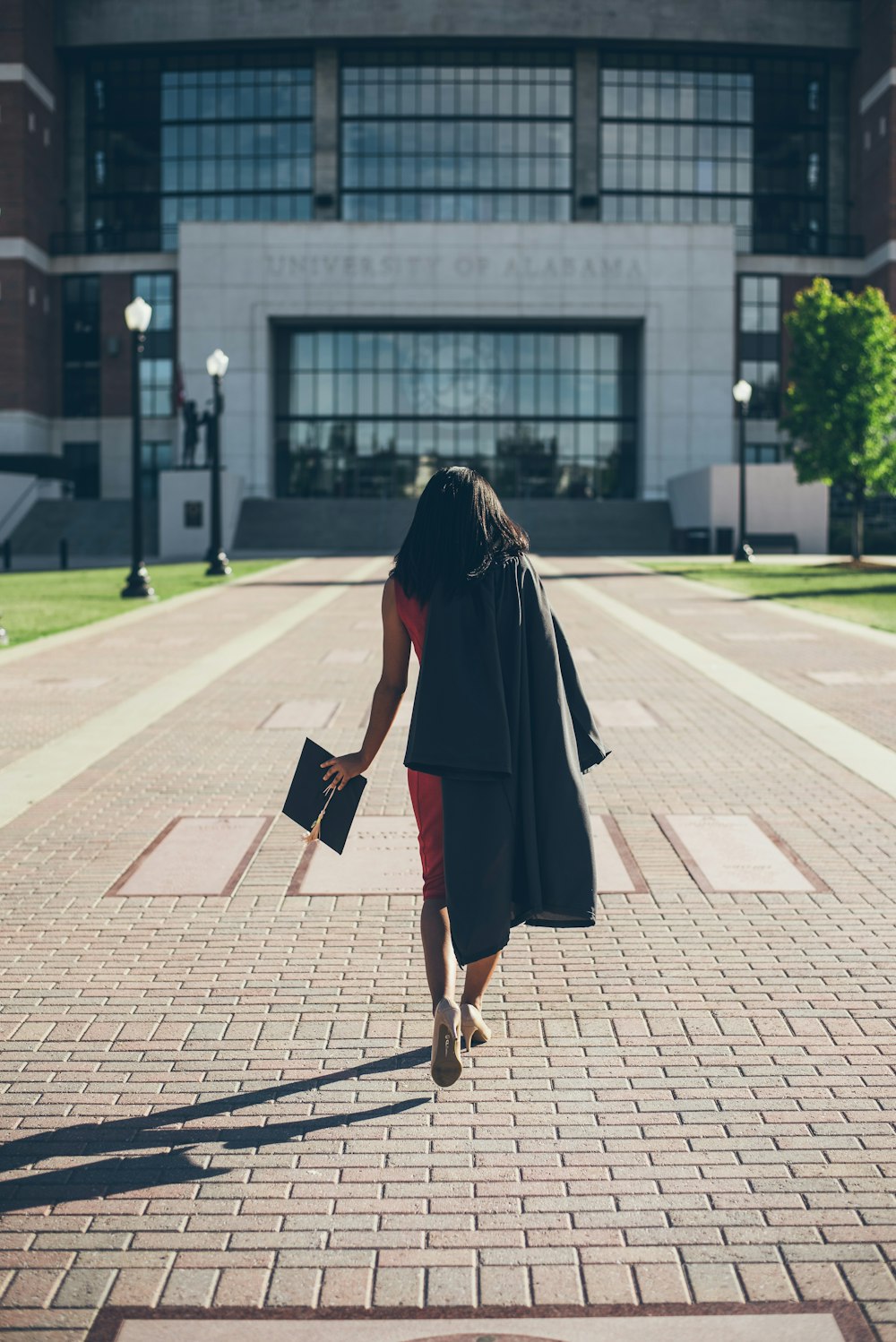 mulher em pé na fachada do prédio da Universidade do Alabama