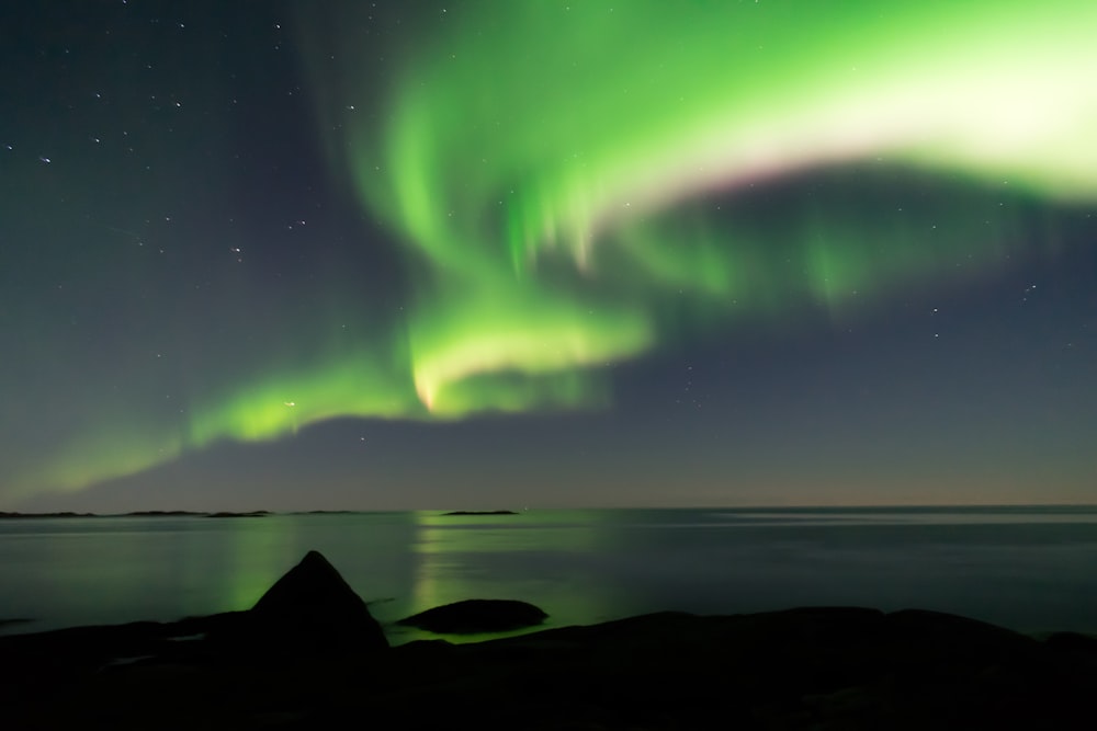 Fotografía de auroras boreales de un cuerpo de agua