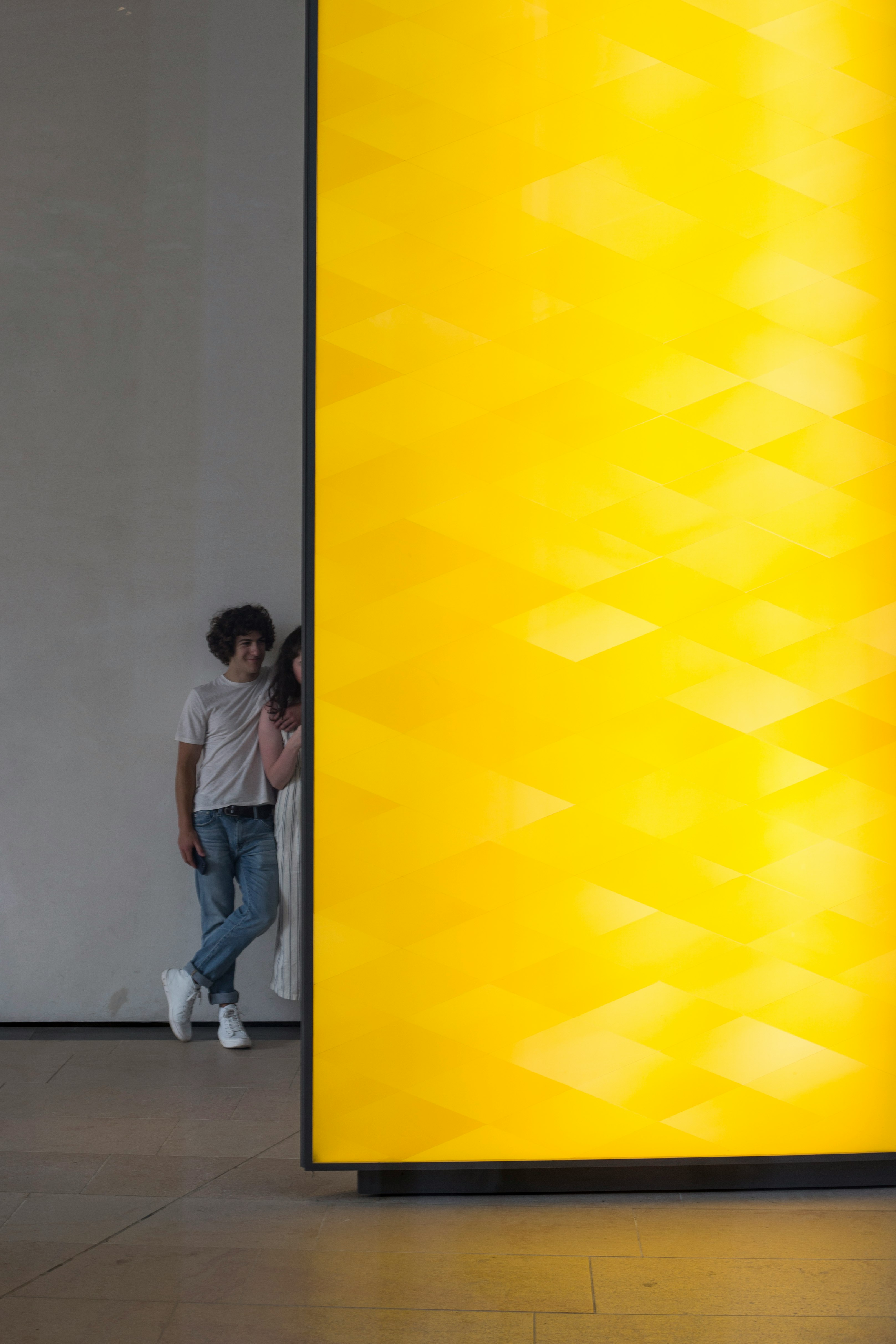 Young couple looking at a yellow art installation