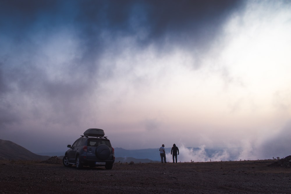 two person standing near SUV during day