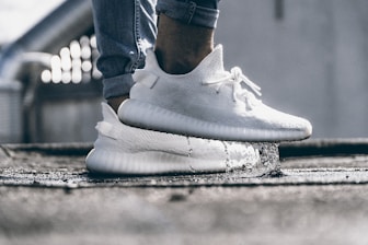 person wearing pair of cream white Adidas Yeezy Boost 350 shoes