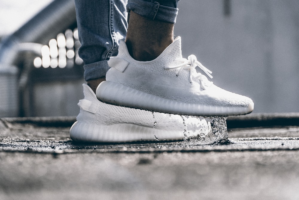 persona con un par de zapatillas Adidas Yeezy Boost 350 blanco crema