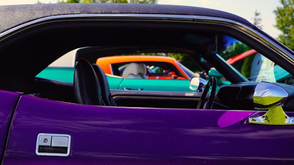 A colorful lineup of diverse cars at an auto show.