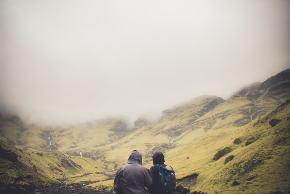 two people standing looking at mountians