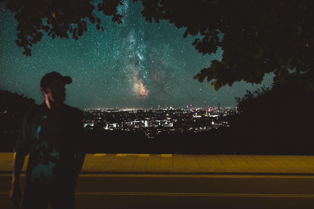 Uomo che cammina sulla strada con la Via Lattea Galaxy