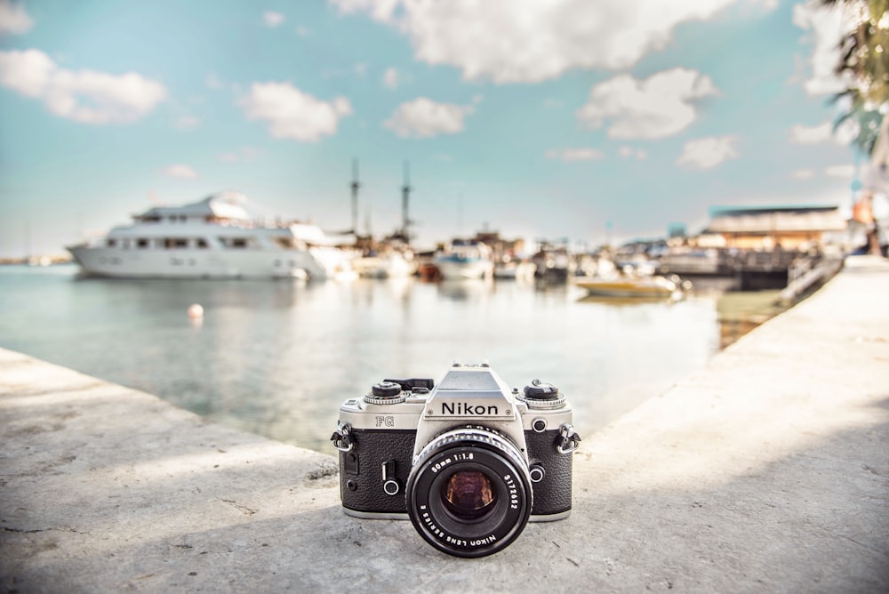 câmera Nikon preta e prata perto de barcos durante o dia