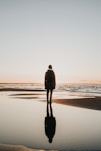 woman standing on sands near shoreline