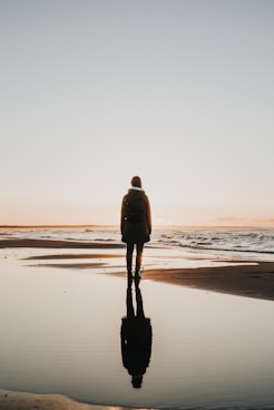 woman standing on sands near shoreline