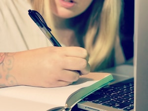 A focused individual writing in a notebook during a coaching session.