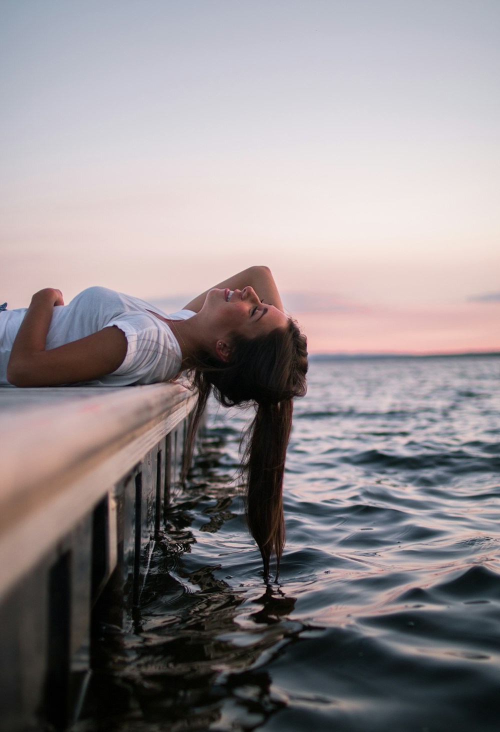 Mujer acostada en el muelle blanco