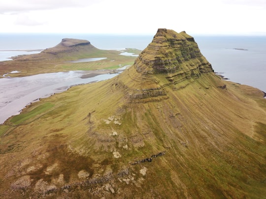 butte surrounded with body of water in Kirkjufell Iceland