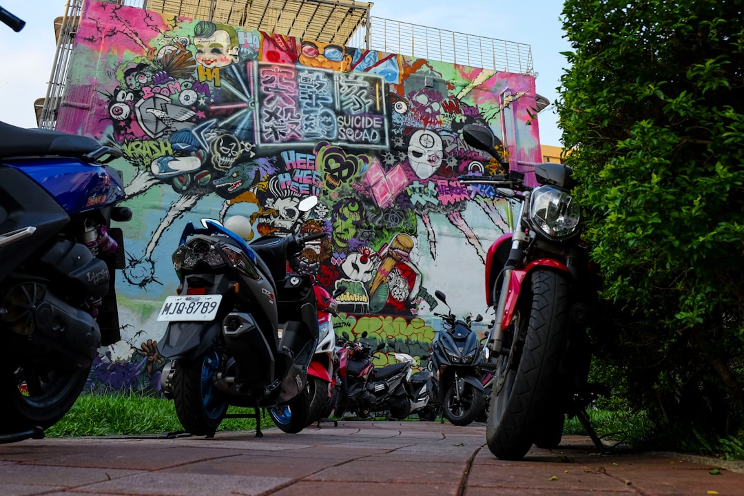 assorted-color motorcycles parking near wall wit graffiti art