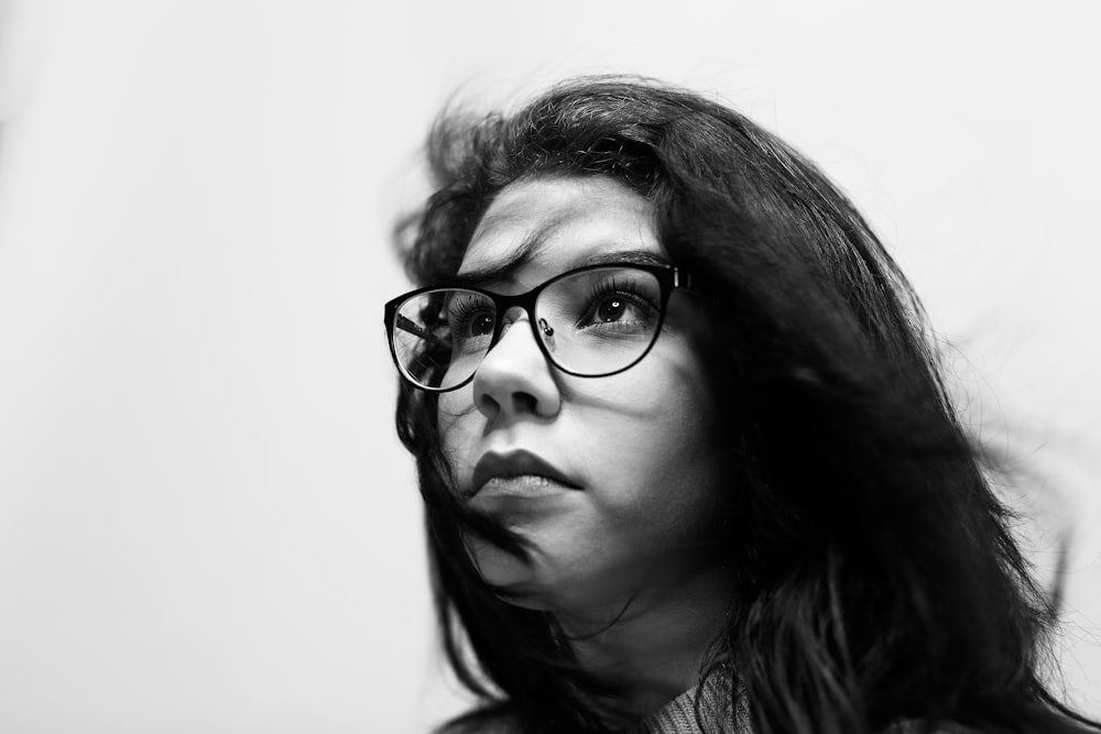Photographie en niveaux de gris d’une femme portant des lunettes