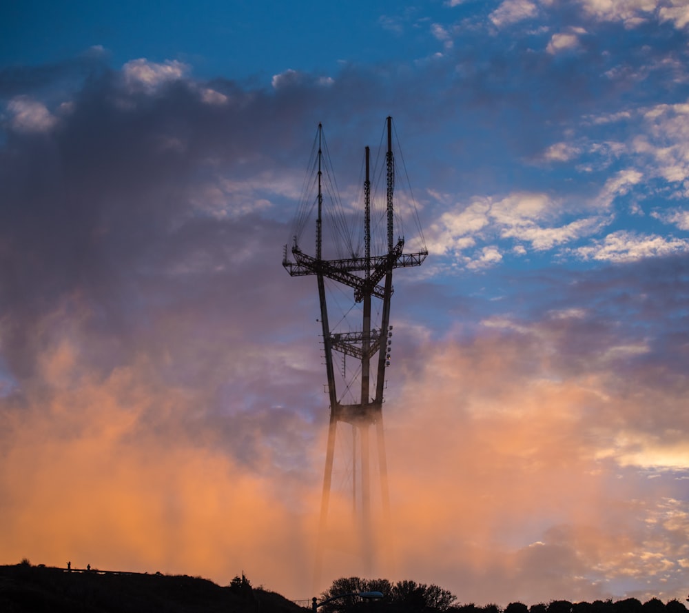 gray transmission tower over the trees