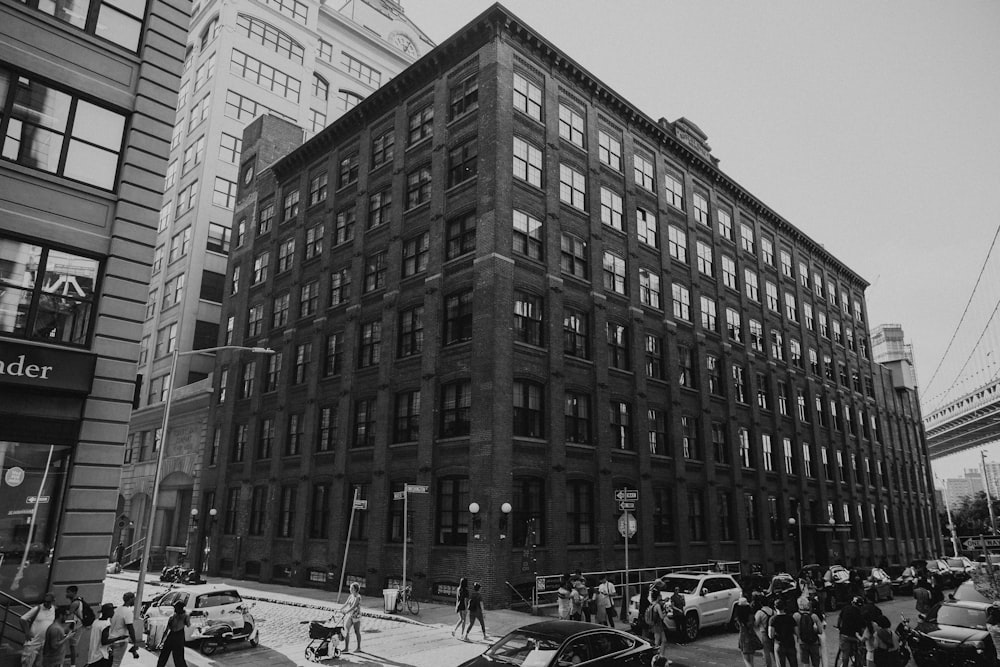 grayscale photo of crowded people near building