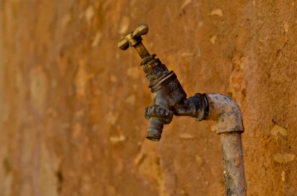 Rusty iron-stained pipe and faucet