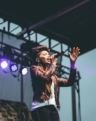 selective focus photography of woman raising left hand