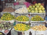 A colorful display of fresh tropical fruits at a market stall.