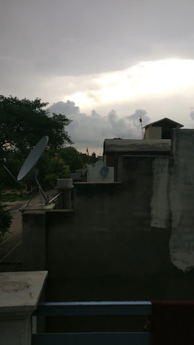 Photo of a technician installing an internet antenna on a rooftop at dusk.