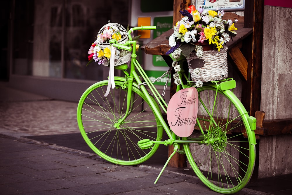 cesta de flores de pétalos en bicicleta urbana verde