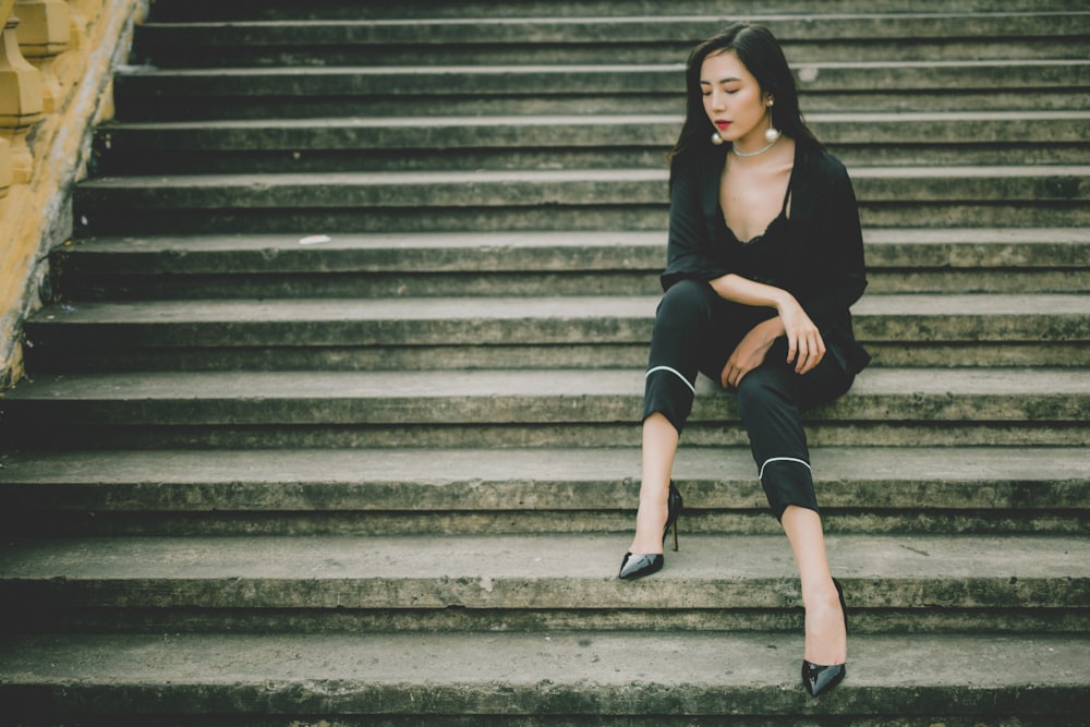 woman sitting on gray stair