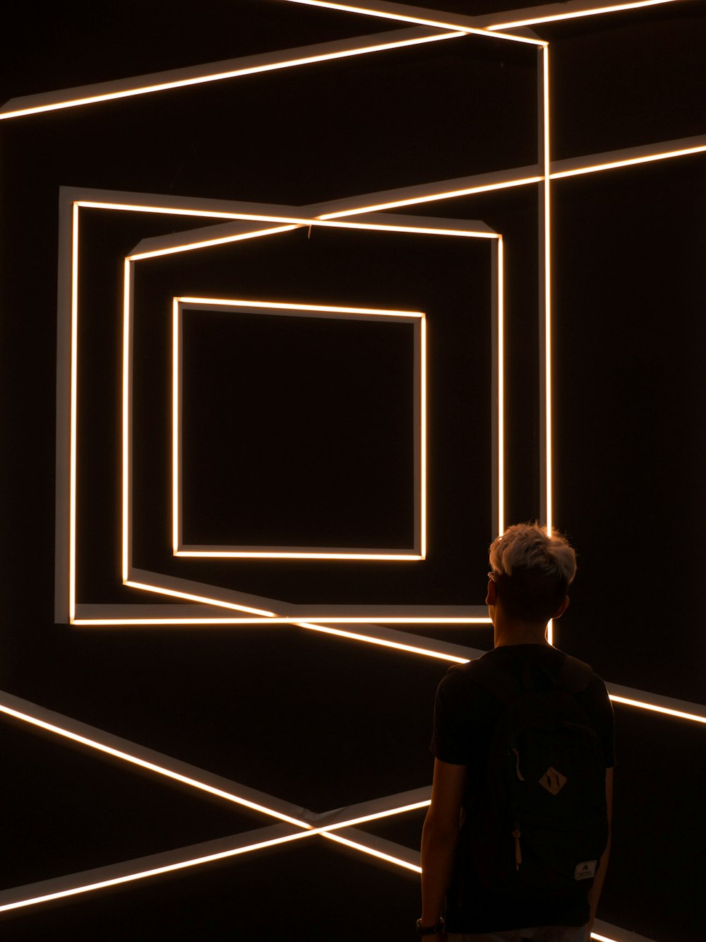 person standing in front of optical illusion wall