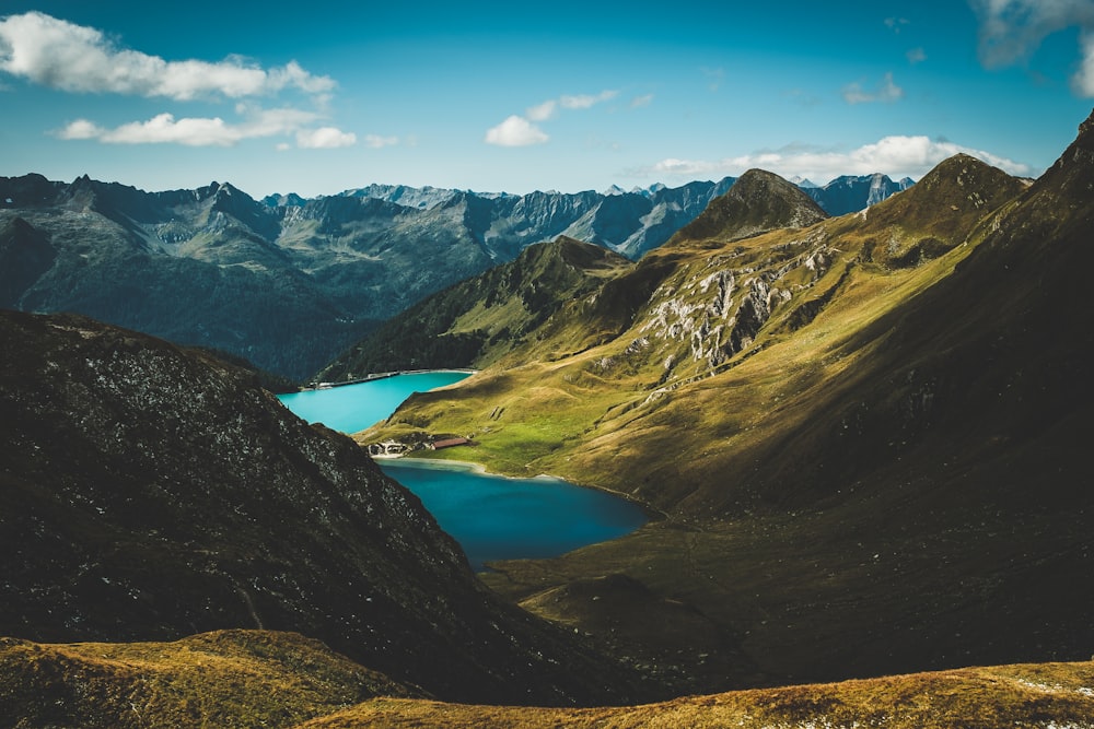 photo of body of water between mountains