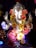 A beautifully decorated statue of Lord Ganesha adorned with vibrant flowers and intricate jewelry. The statue features detailed craftsmanship with vibrant colors and a serene expression.