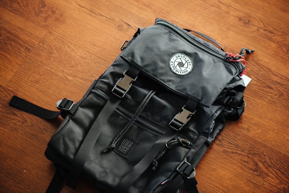 black backpack on wooden deck