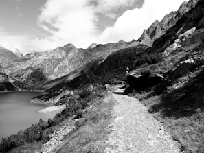 Calm mountain landscape with a winding trail under a clear blue sky