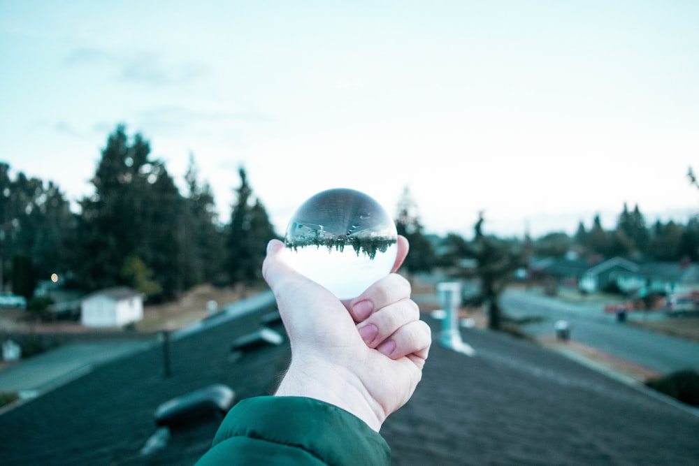 person holding black glass ball