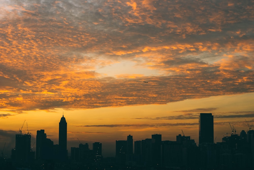 silhouette city buildings under clouds