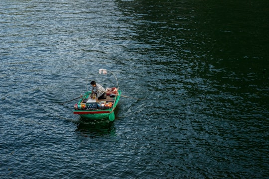 person on green boat in Ha Long Bay Vietnam