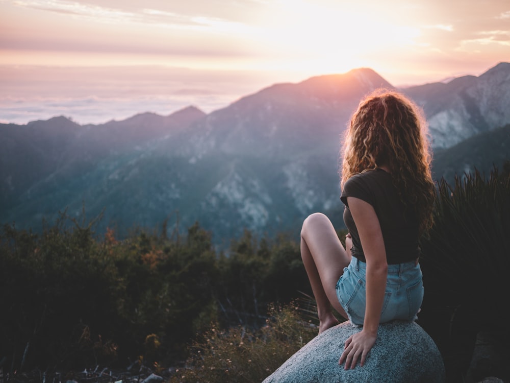 Frau sitzt auf Felsen