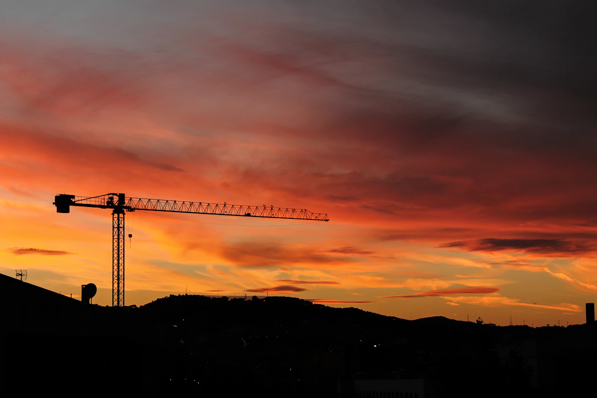 Chantier de construction neuve, grue au crépuscule