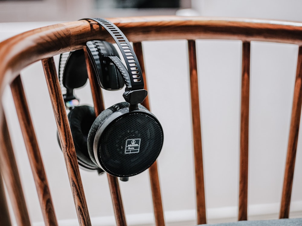 black cordless headphones on brown wooden chair