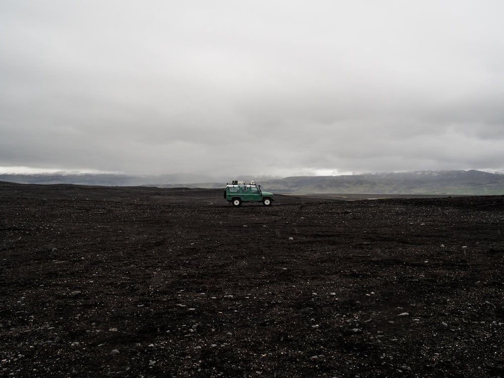 green SUV on black soil taken at daytime