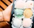 Close-up of hands holding a tray of assorted gourmet geladinhos with vibrant colors