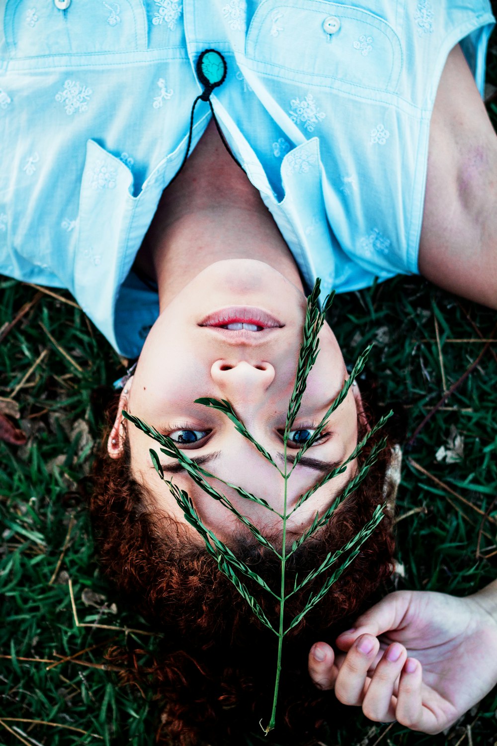 woman lying on green grass during daytime