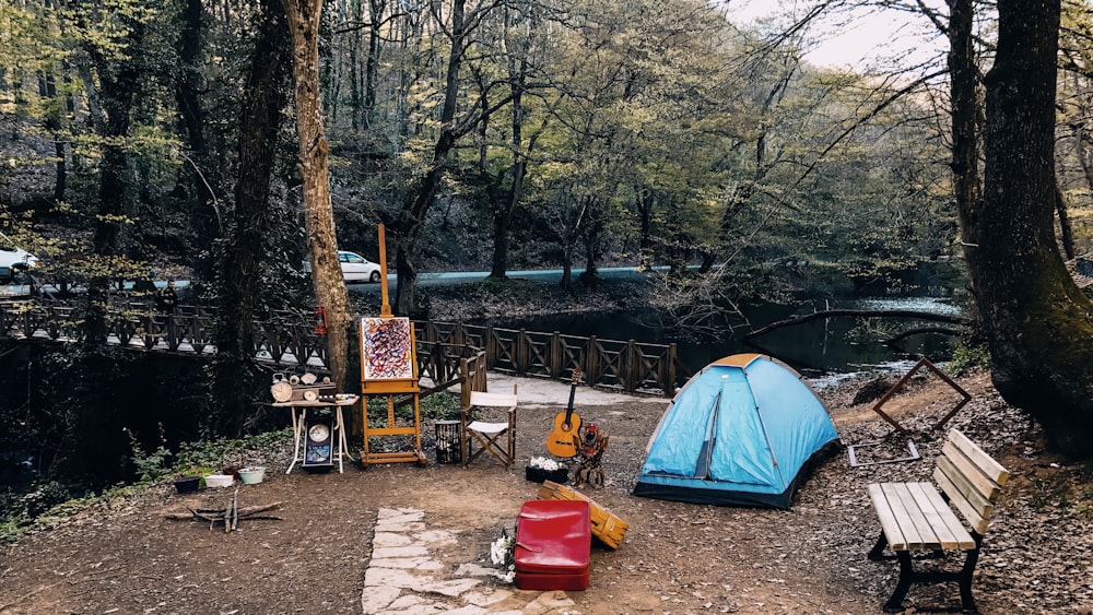 a blue tent sitting in the middle of a forest