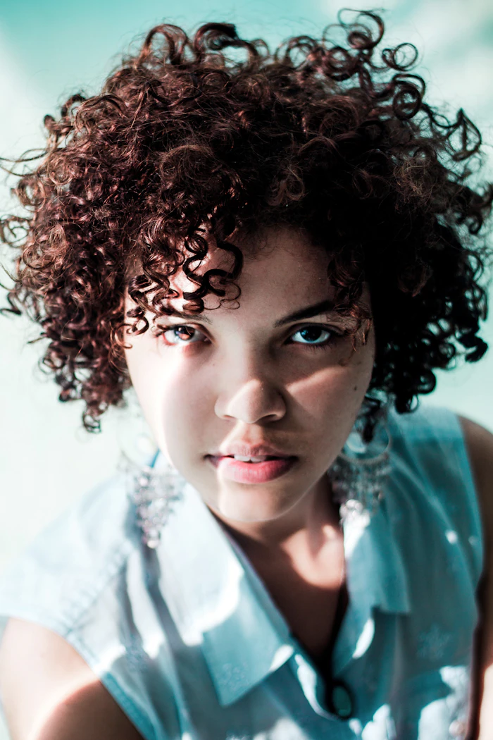Avant : cheveux bruns bouclés naturels, sans coloration